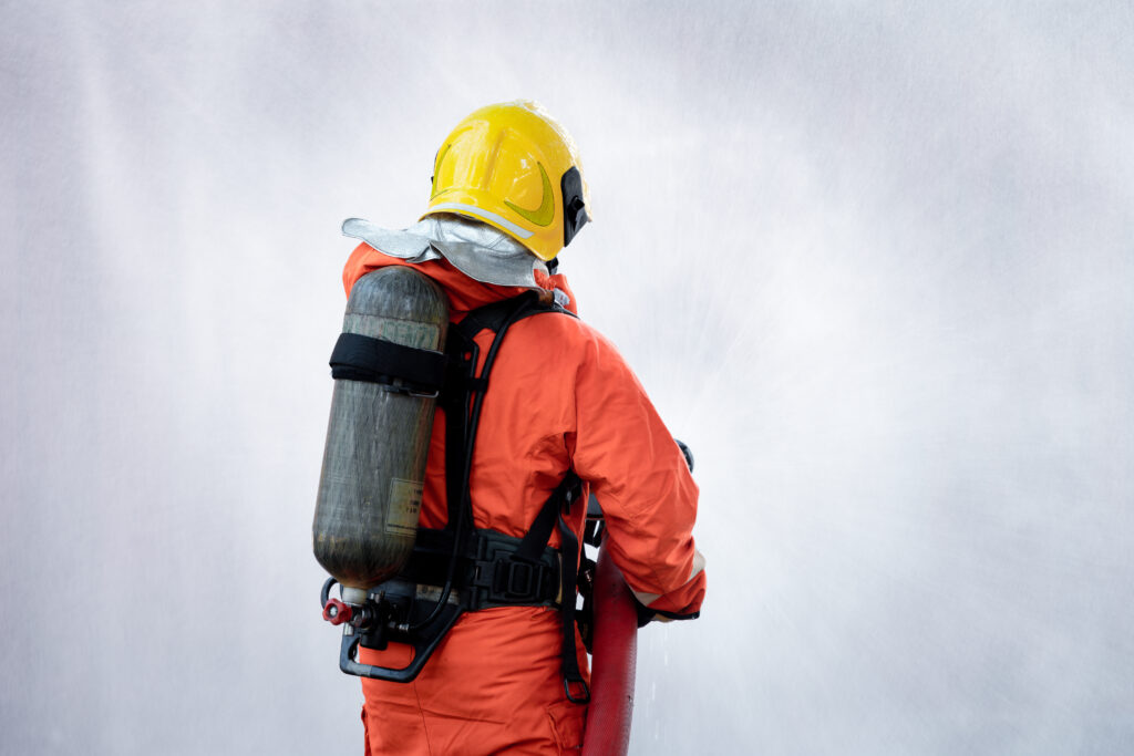 Fireman wearing firefighting suite using fire extinguisher fighting fire equipment and accessories i